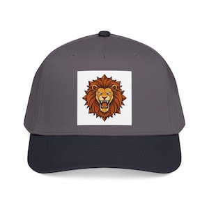 Può includere: Cappellino da baseball con corona grigia e visiera blu navy. Il cappellino presenta una toppa quadrata con un'illustrazione dettagliata della testa di un leone ruggente nei toni del marrone, arancione e giallo.