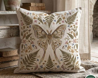 Può includere: Cuscino quadrato con design botanico. Presenta una grande farfalla al centro, circondata da felci e piccoli fiori nei toni del marrone, verde e rosa. Il cuscino è realizzato in cotone naturale.