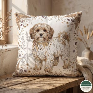May include: Square decorative pillow featuring a dog illustration with a floral design. The dog is depicted in shades of brown and cream, surrounded by a border of brown and purple flowers and leaves. The pillow is on a wooden surface.