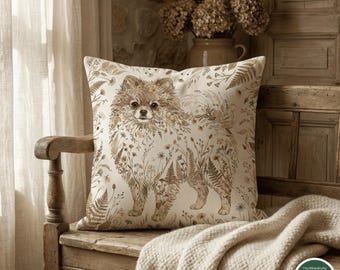 May include: A square throw pillow featuring a beige fabric cover with a brown illustration of a Pomeranian dog composed of various botanical elements like ferns and wildflowers. The design is printed on the front of the pillow in a neutral tone.