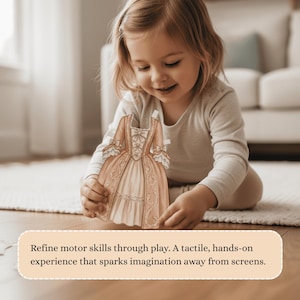 Pu&ograve; includere: Una bambina tiene in mano un vestito di carta per bambole. L'abito &egrave; color pesca e crema con intricati dettagli di pizzo e fiocchi. Il testo in basso recita: "Affina le capacit&agrave; motorie attraverso il gioco. Un'esperienza tattile e pratica che accende l'immaginazione lontano dagli schermi."