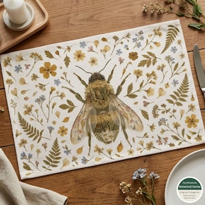 May include: A rectangular placemat featuring a large central bumblebee illustration surrounded by a pattern of pressed-style yellow flowers, green fern leaves, and small blue blossoms on a white background, creating a botanical aesthetic.
