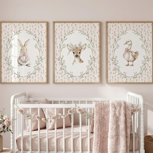 Può includere: Tre stampe incorniciate per la cameretta, raffiguranti un coniglietto, un cerbiatto e un'anatra, ciascuno all'interno di una ghirlanda floreale. Le stampe hanno una palette di colori pastello e sono esposte sopra una culla bianca con biancheria da letto rosa.