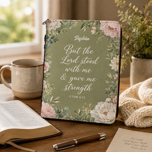 May include: A sage green rectangular book cover featuring a floral border of pink and white peonies and green leaves. The text reads: Sophia, But the Lord stood with me & gave me strength, 2 TIM 4:17. The cover has a zipper closure along the side.