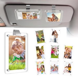 May include: A set of clear acrylic magnetic photo frames designed to clip onto a vehicle sun visor. Each frame features a transparent rectangular body with four silver-toned corner screws and a metal mounting clip for secure attachment.