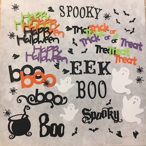 May include: A collection of Halloween themed paper cutouts in black, orange, green, purple, and white. The cutouts include the words "Happy Halloween", "Boo", "Spooky", "Trick or Treat", and "EEK BOO". There are also cutouts of bats, spiders, witches' hats, and ghosts.