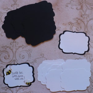 May include: A set of blank black and white scalloped edge cardstock tags with a bee and the text "bumble bee come dance with me!" on one tag.