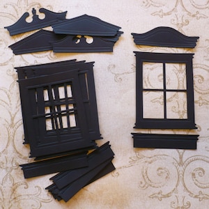 May include: Black paper craft pieces for a window frame and a decorative top. The window frame has a grid pattern and the top has a curved design.