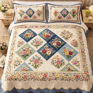 Puede incluir: Un edredón floral y dos fundas de almohada a juego. El edredón presenta un patrón de diamantes repetido con ramos de flores en tonos de rosa, amarillo y azul. El borde y las fundas tienen un borde festoneado y un ribete azul.