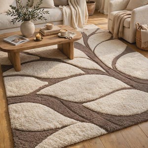 May include: A rectangular area rug featuring a high-pile, tufted texture with a repeating pattern of large, cream-colored leaf shapes set against a dark brown background, creating a bold contrast across the entire floor covering surface.
