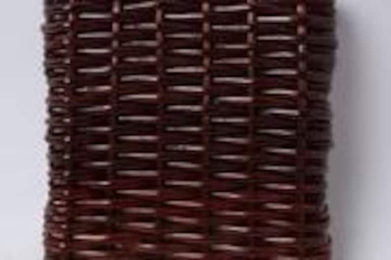 May include: A rectangular, dark brown woven basket with a textured surface. The basket is made of tightly woven strips of material, creating a grid-like pattern. The basket's design is simple and functional.