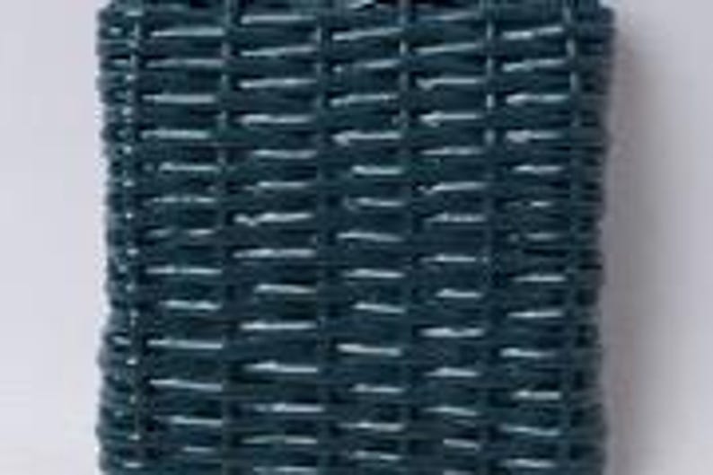 May include: A rectangular, dark teal woven basket with a tight weave pattern. The basket's sides are straight, and the weave creates a textured surface. The basket is likely made of a durable material, suitable for storage or decorative purposes.