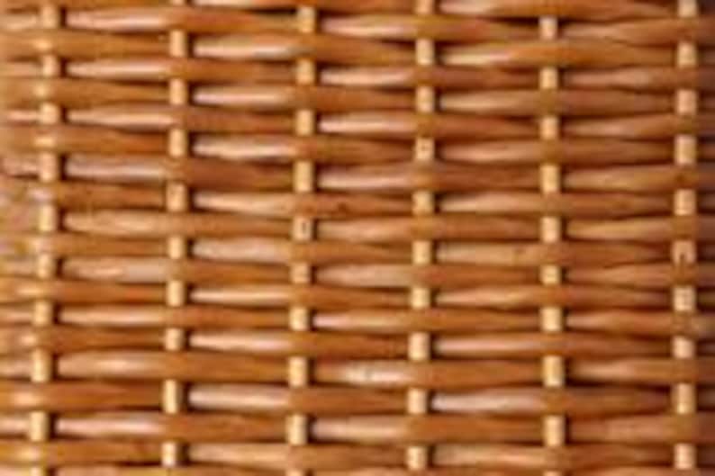 May include: Close-up of a woven wicker pattern in shades of brown. The texture shows a repeating pattern of horizontal and vertical interwoven strips, creating a natural, rustic appearance. The weave is tight and even, with variations in color.