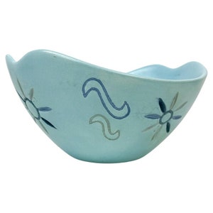 May include: A light blue ceramic bowl with a wavy rim and abstract designs in shades of blue, gray, and white.
