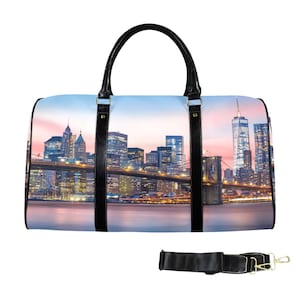 May include: A duffel bag featuring a cityscape design with a bridge and buildings under a pink and blue sky. The bag has black handles and straps, with a detachable shoulder strap.