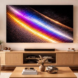 May include: A modern living room featuring a large flat-screen TV displaying an abstract, colorful design. The TV is mounted above a wooden entertainment center. The room is decorated with plants and a neutral color palette.