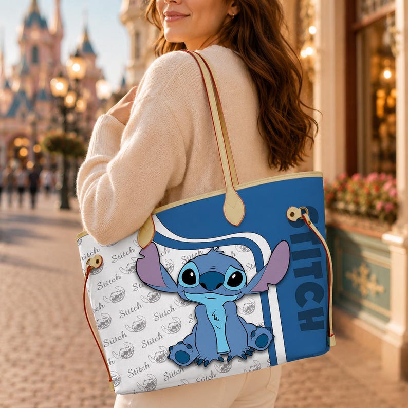 Puede incluir: Un bolso tote azul y blanco con el personaje Stitch de la pel&iacute;cula de Disney Lilo & Stitch. El bolso tiene un fondo azul con la palabra "STITCH" impresa verticalmente. El cuerpo principal del bolso tiene un fondo blanco con un patr&oacute;n repetido de Stitch.