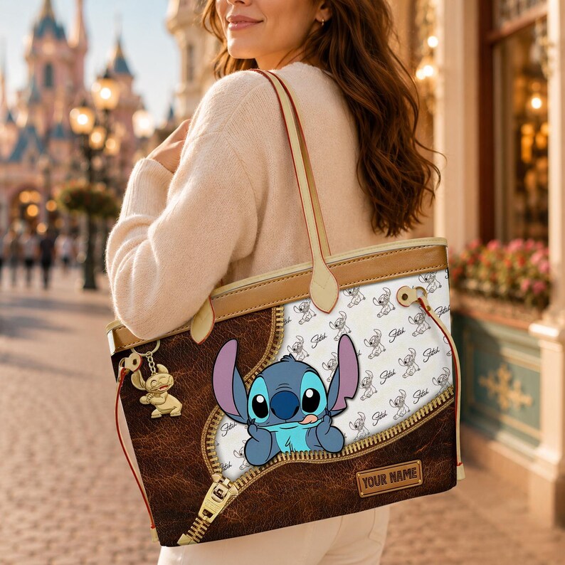 Puede incluir: Un bolso tote marr&oacute;n y beige con un dise&ntilde;o de personaje de dibujos animados. El bolso tiene un dise&ntilde;o de cremallera con un gr&aacute;fico de personaje de dibujos animados. Tiene asas beige y un llavero a juego.