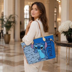 May include: A blue tote bag featuring a cartoon character, with the word "STITCH" in large blue letters. The bag has brown handles and a light blue background with repeating character and heart patterns.