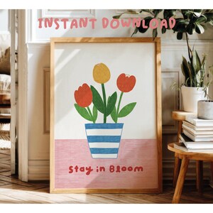 May include: A set of three ceramic mugs with a speckled, cream-colored glaze. Each mug features a different hand-painted floral design in shades of blue, green, and yellow. The mugs have a simple, modern shape.