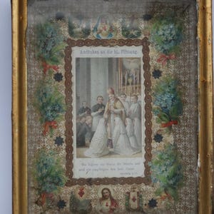 May include: Antique framed religious print with gold trim. The print features a central image of a religious ceremony, surrounded by floral and star motifs. Text in German is visible at the top and bottom of the image.