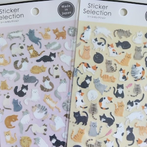 Pode incluir: Duas folhas de autocolantes de gatos com a etiqueta Sticker Selection e Made in Japan. A folha da esquerda tem um fundo roxo claro e a da direita um fundo amarelo claro. Ambas as folhas apresentam numerosas ilustrações pequenas de gatos.