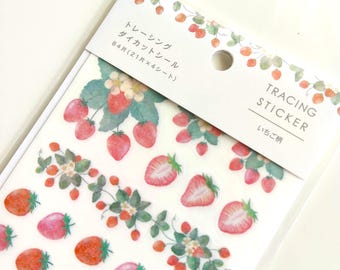 Puede incluir: Un paquete de 84 pegatinas troqueladas de papel vegetal con ilustraciones de fresas al estilo acuarela. El encabezado dice Tracing Sticker con caracteres japoneses. Las pegatinas muestran fresas rojas enteras y cortadas con hojas verdes.