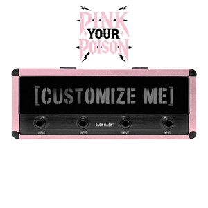 May include: A pink audio device with the text "[CUSTOMIZE ME]" on a black panel. The device has four input jacks labeled "INPUT" and the text "JACK RACK". Above, the words "PINK YOUR POISON" are displayed in pink.
