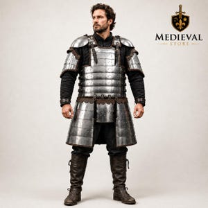 May include: A suit of steel lamellar armor featuring overlapping metal plates, leather straps, and shoulder pauldrons, worn over a black quilted long-sleeve tunic and dark trousers, paired with brown leather boots. The Medieval Store logo is visible.