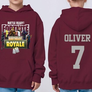 Pu&ograve; includere: Felpa con cappuccio bordeaux con grafica Fortnite Birthday Royale sul davanti. Il retro della felpa mostra il nome "OLIVER" e il numero "7" in grigio. La felpa ha una tasca frontale e un cappuccio.