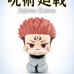 May include: A Jujutsu Kaisen Ryomen Sukuna figurine. The figure has red hair, red eyes, and facial markings. It is wearing a white outfit with a black collar and a blue tie. The text "Jujutsu Kaisen" and "Ryomen Sukuna" are also visible.