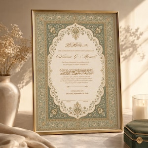 May include: A framed Islamic marriage certificate featuring a sage green and gold floral border with intricate patterns. The document includes Arabic calligraphy and English text stating, This agreement is to certify the marriage of Amna & Murad.