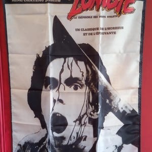 May include: A white banner with the word "ZOMBIE" in red, featuring a black and white illustration of a man with a knife. Text in French includes "UN CLASSIQUE DE L'HORREUR ET DE L'ÉPOUVANTE."