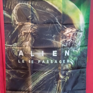 Può includere: Uno stendardo da parete rettangolare in tessuto con una grafica scura e dettagliata della creatura Xenomorfo della serie cinematografica Alien. Il testo ALIEN LE 8E PASSAGER è stampato in bianco al centro. Lo stendardo ha occhielli metallici.
