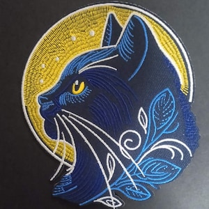 Può includere: Toppa ricamata raffigurante il profilo di un gatto nero con occhi gialli e baffi bianchi, su sfondo di luna gialla. Accenti floreali blu e dettagli bianchi completano il design. Per abbigliamento o accessori.