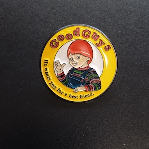 May include: A round enamel pin featuring a cartoon character with red hair wearing blue overalls and a multi-colored striped shirt. The yellow border displays the red text Good Guys and the black text He wants You for a best friend.