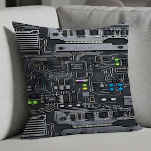 Könnte beinhalten: Ein dekoratives Kissen mit einem Leiterplatten-Design. Der schwarze Hintergrund zeigt eine komplexe Anordnung von silbernen und grauen Komponenten, darunter Chips, Schaltkreise und Anschlüsse. Das Design enthält Text wie "CPU" und "Chip A02".