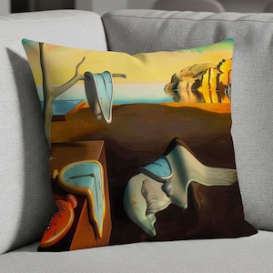 May include: Cushion with a surrealist artwork depicting melting clocks in a desert landscape under a yellow sky. The image features a dreamlike scene with soft colours and unusual shapes, reminiscent of a famous painting.