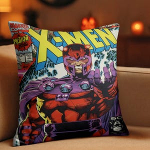 Peut inclure: Coussin carré représentant une couverture de bande dessinée avec le titre "X-MEN". L'œuvre d'art représente un personnage en costume rouge et violet avec un casque, sur un fond bleu et blanc. Le logo Marvel Comics est visible en haut à gauche.