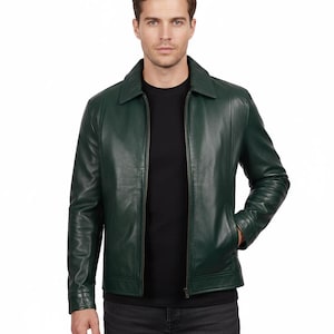 May include: A dark green leather jacket with a collared neckline and a front zipper closure. The jacket has long sleeves and pockets. The person in the image is wearing a black shirt and dark gray jeans.