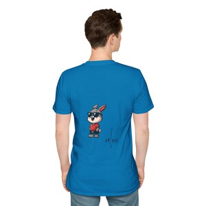 May include: A turquoise blue t-shirt with a cartoon rabbit wearing sunglasses and a red shirt. The word "relax" is written in a handwritten style on the shirt.