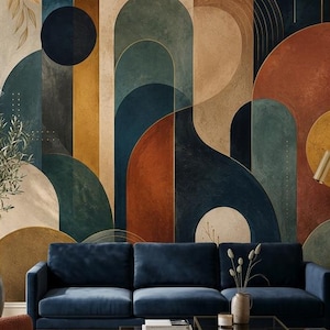May include: A large wall mural featuring geometric arches and circles in shades of navy blue, terracotta, mustard yellow, and beige. A navy blue velvet sofa, a rust-colored armchair, and a glass coffee table are positioned in front of the wall.