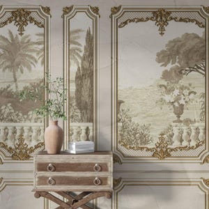 Puede incluir: Un panel decorativo de pared con una escena de paisaje en tonos sepia, enmarcado con adornos dorados ornamentados. Un pequeño cofre de madera con dos cajones y un jarrón con vegetación se encuentra frente al panel. Una pila de libros está en el cofre.
