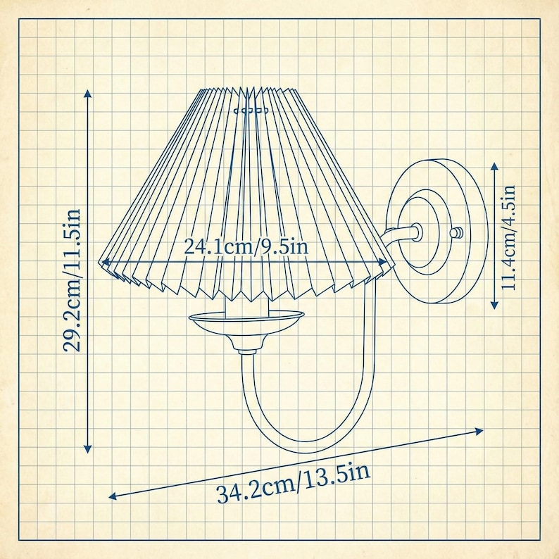 May include: A wall-mounted lamp with a pleated lampshade. The lamp's dimensions are 29.2cm/11.5in high, 24.1cm/9.5in wide, and 34.2cm/13.5in long. The lamp has a circular wall mount and a curved arm supporting the shade. The design is illustrated on a grid background.
