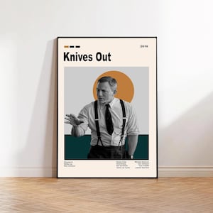 May include: A framed poster for the movie "Knives Out" featuring Daniel Craig. The poster has a minimalist design with a beige background, a teal stripe, and an orange circle behind Craig. The movie title and credits are also displayed.