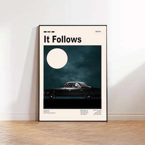 May include: A framed movie poster for "It Follows" with a black car under a full moon. The poster has a teal and cream color scheme, with the title in bold black letters. The year 2014 is in the upper right corner.
