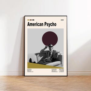 Könnte beinhalten: Gerahmtes Poster mit dem Filmtitel "American Psycho" in schwarzer Schrift. Das Poster zeigt einen Mann mit Sonnenbrille auf einem Sofa, einen burgunderroten Kreis und einen cremefarbenen Hintergrund. Mit Cast und Crew.