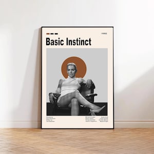 Może przedstawiać: Oprawiony plakat do filmu "Basic Instinct" z czarno-białym zdjęciem kobiety siedzącej na krześle. Plakat ma beżowe tło z tytułem filmu pogrubionymi czarnymi literami i rokiem 1992.