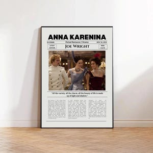 May include: A framed movie poster for Anna Karenina directed by Joe Wright. The poster features a central photograph of three people in period attire, with the film title, release date, IMDb rating, and a descriptive text block in black font.