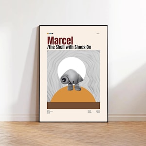 Könnte beinhalten: Gerahmtes Poster mit dem Text "Marcel /the Shell with Shoes On". Das Poster zeigt eine Cartoon-Muschelfigur mit Schuhen. Die Muschel ist grau, vor einem beigefarbenen Hintergrund mit einem braunen und orangefarbenen Design.